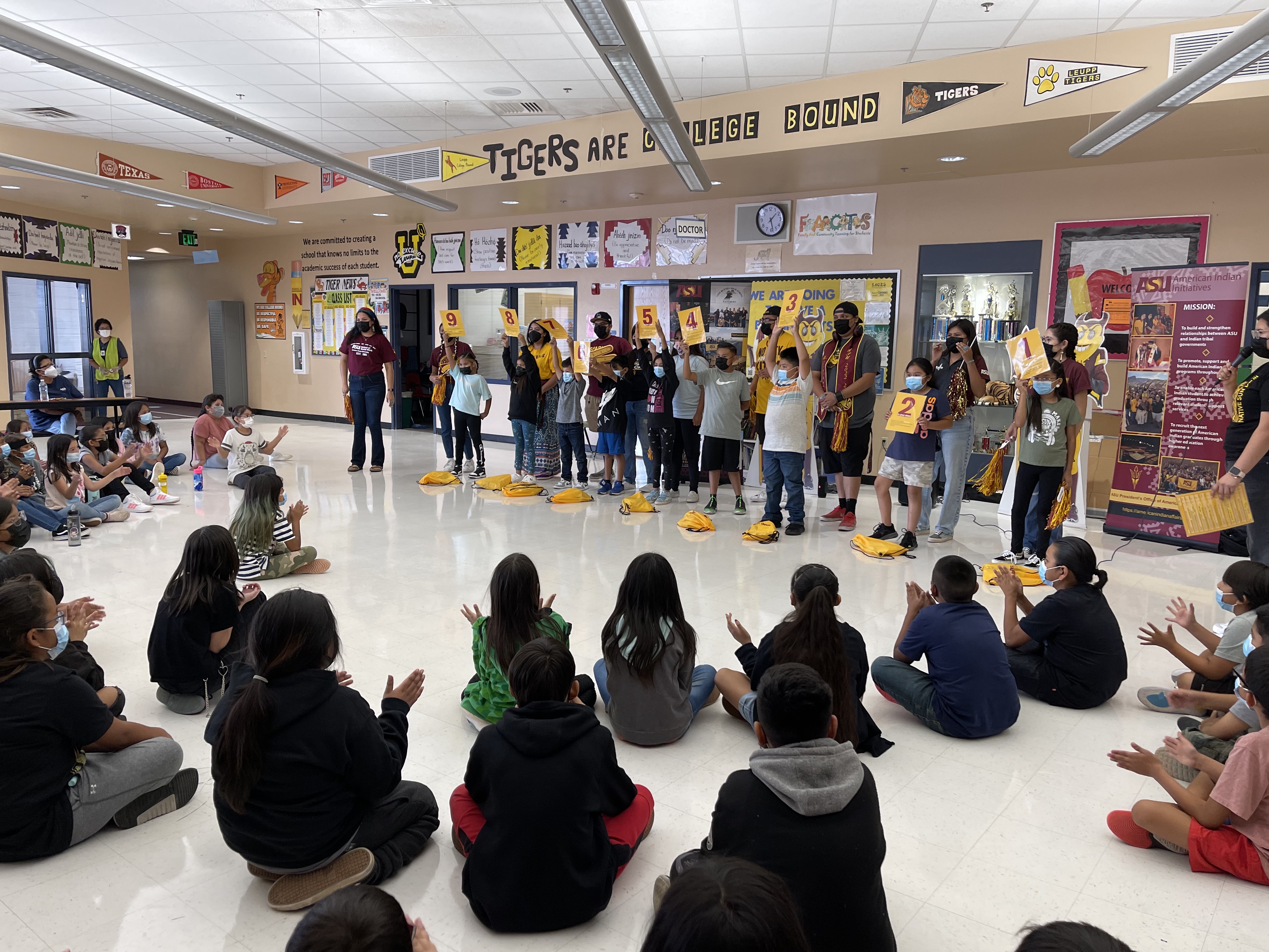 young students standing in front of crowd of peers during ASU TNT visit to school