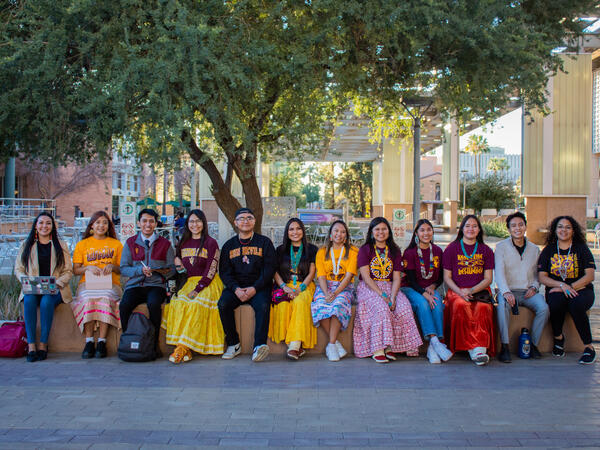 12 students sitting outside as a group on the ASU Tempe campus